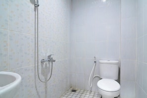 Un baño pequeño con inodoro, ducha y lavamanos.
