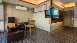 A modern living room with a flat-screen TV, leather sofa, wooden coffee table, and built-in air conditioning unit. - Cloud Home (Luodong)