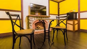 A cozy room with a fireplace, two chairs, a table, and a TV. - Cloud Home (Luodong)