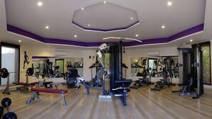 A gym with various exercise equipment, including treadmills, weight machines, and free weights. - The Tigress Spa and Resort (Sawai Madhopur)