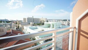 A high-rise building with a rooftop terrace, offering views of surrounding urban structures. - Hotel From Okinawa (Naha)