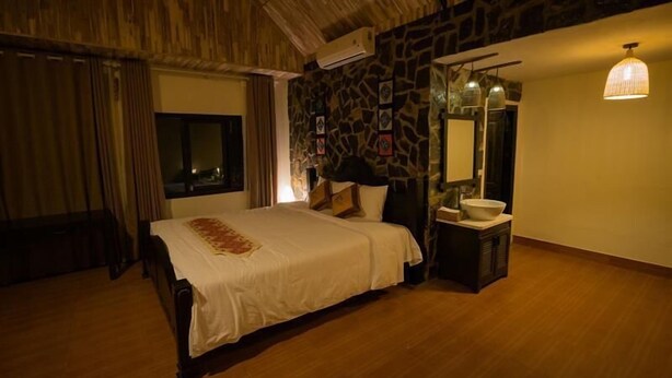 A bedroom with a bed, a mirror, a sink, and a window. - Mai Chau Nature Lodge - Hostel (Mai Chau)