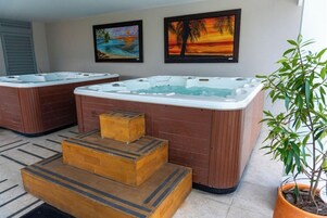 Un área de spa con dos jacuzzis y escalones de madera que los conectan.