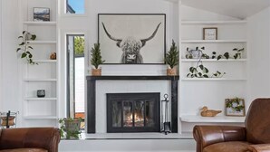 A living room with a fireplace, leather sofas, and a wall-mounted bull head sculpture. - Rimview Haven: Hot Tub, Waterfall Trail & Golf! (Jerome)