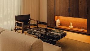 A living room with a sofa, a chair, a coffee table, and a wooden cabinet with a shelf. - Campzero Active & Luxury Resort (Ayas)