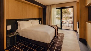 A hotel room with a bed, a nightstand, a lamp, a view of the outdoors through a glass door, and a TV. - Campzero Active & Luxury Resort (Ayas)