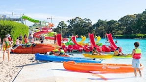 A beach with colorful water slides and inflatable boats. - Solanas Punta Del Este Spa Resort (Punta del Este)
