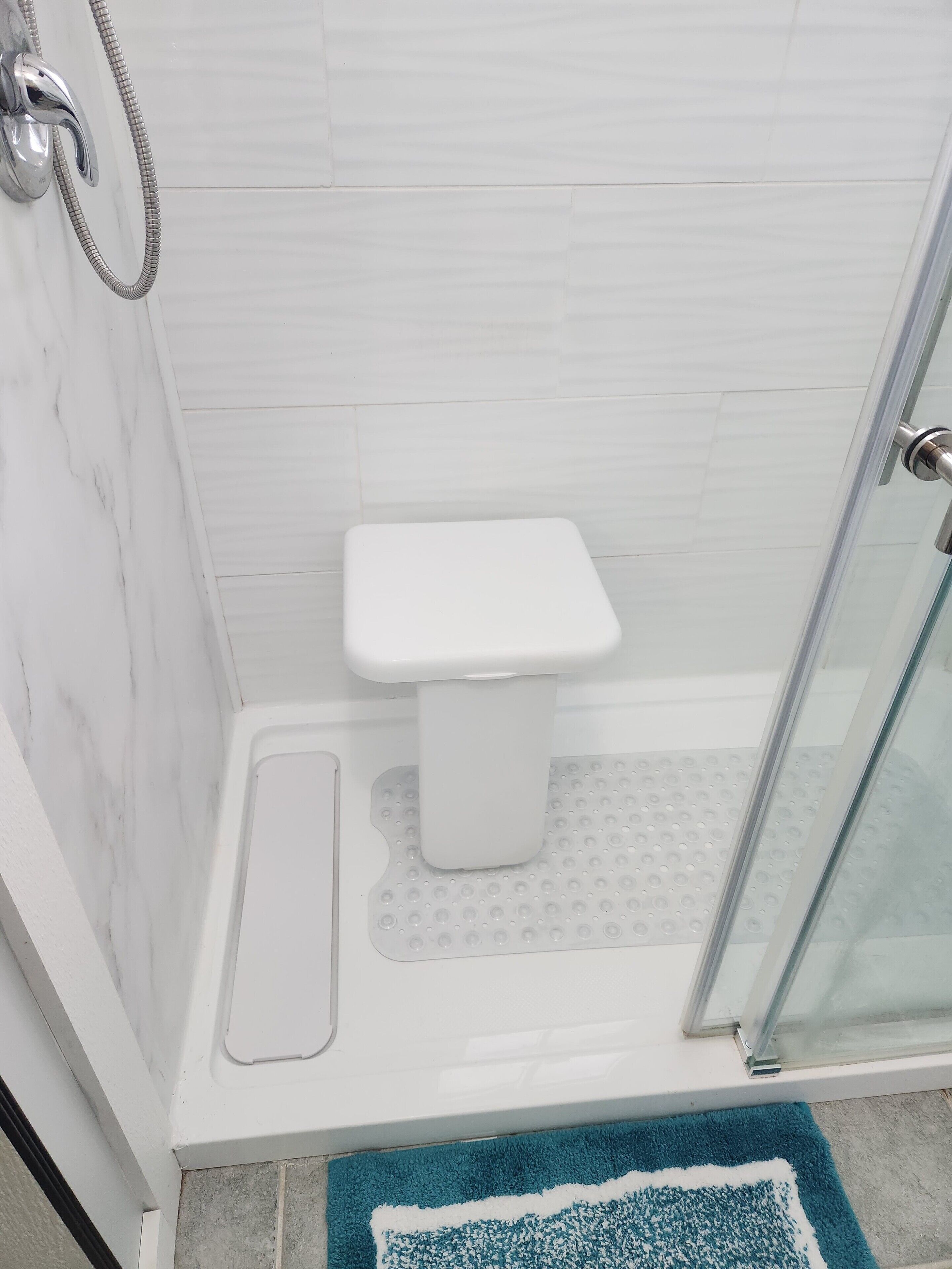 Une salle de bain avec douche, toilettes et porte en verre.