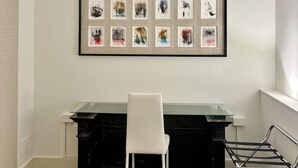 A modern office space with a black desk, a white chair, and a framed art display on the wall. - Avanguardia Suite Ferrara (Ferrara)