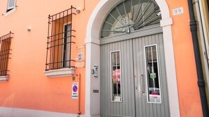 A building with a grey door, a sign indicating a no parking zone, and a number '99' on the wall. - Avanguardia Suite Ferrara (Ferrara)