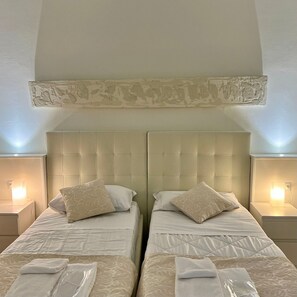 A double room with two beds, each with a headboard, bedside tables, and lamps. - Avanguardia Suite Ferrara (Ferrara)