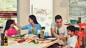 A family dining at a restaurant with a view of the cityscape, including a recognizable landmark. - Sealine Beach, a Murwab Resort (Mesaieed)