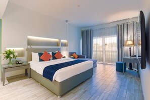Une chambre d’hôtel moderne avec un grand lit, des tables de chevet, un bureau et une télévision.