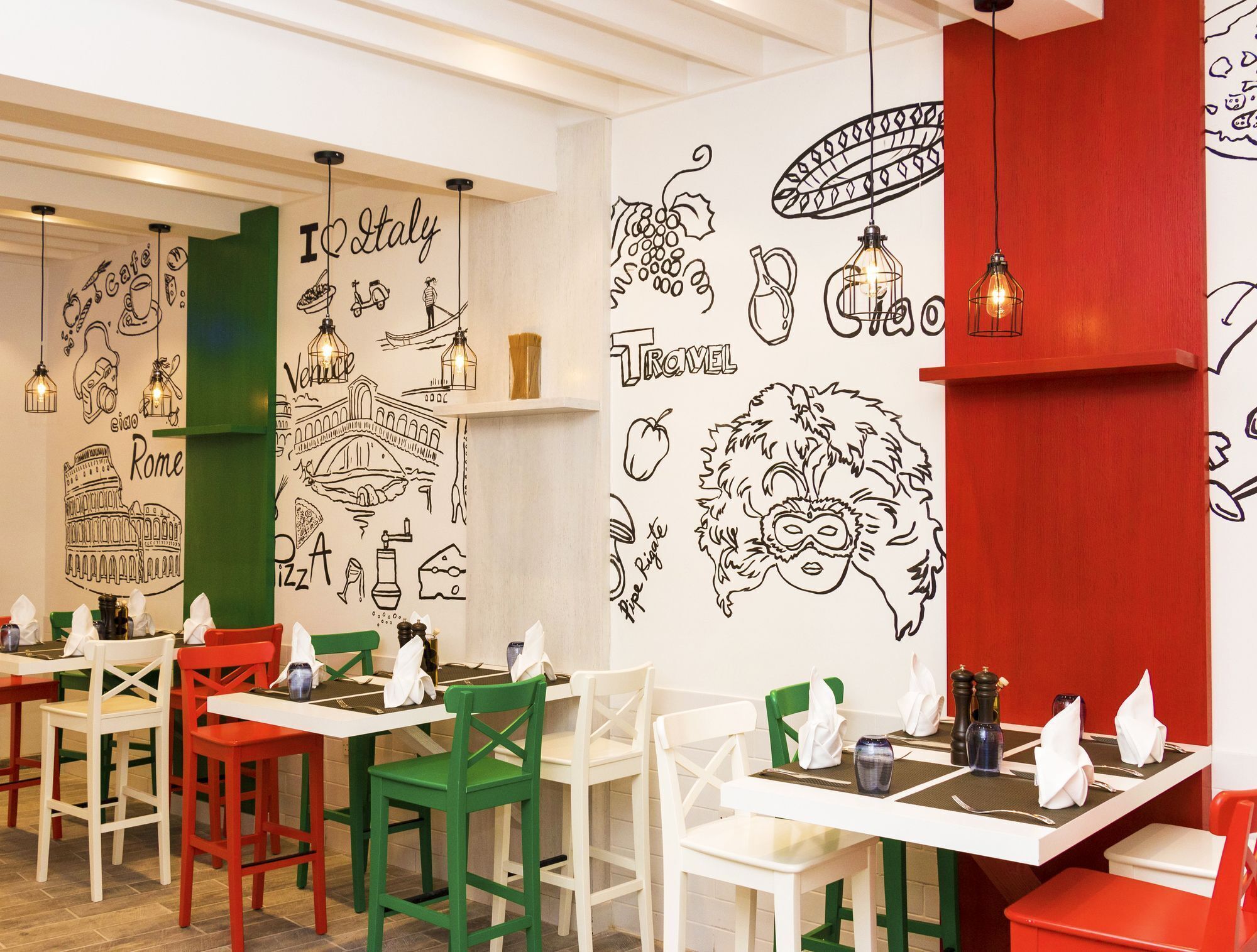 A restaurant interior with tables and chairs, featuring wall art depicting travel and food.
