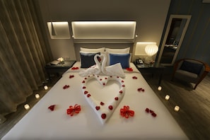A hotel room with a neatly made bed, a desk with a lamp, a chair, and a bedside table with a phone. - Sealine Beach, a Murwab Resort (Mesaieed)