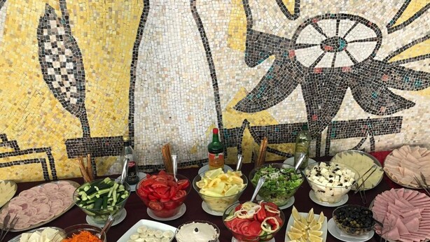 A buffet table with various food items and condiments. - Central Mamaia (Constanta)