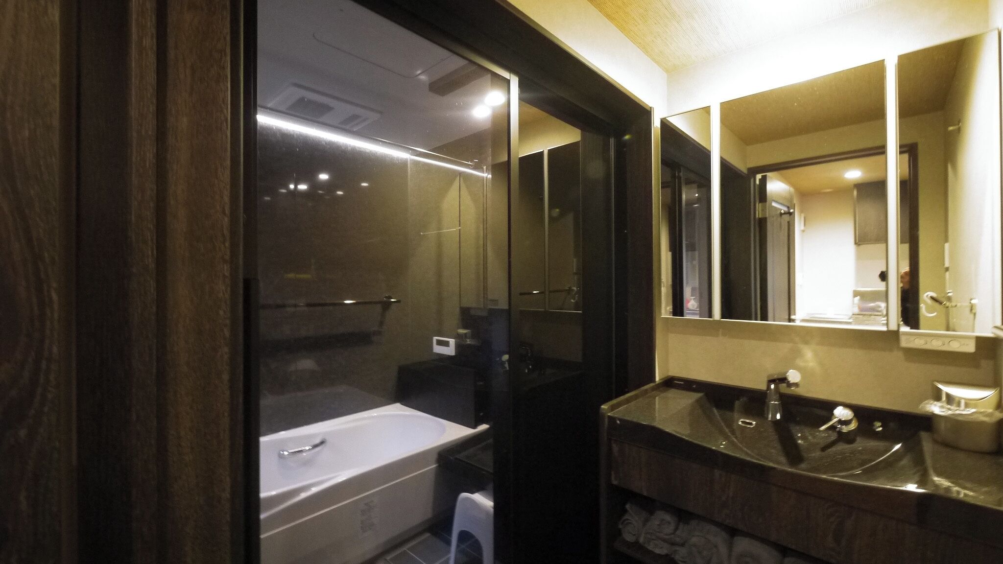 Ein modernes Badezimmer mit einer Badewanne, einem Waschbecken und einem großen Spiegel.
