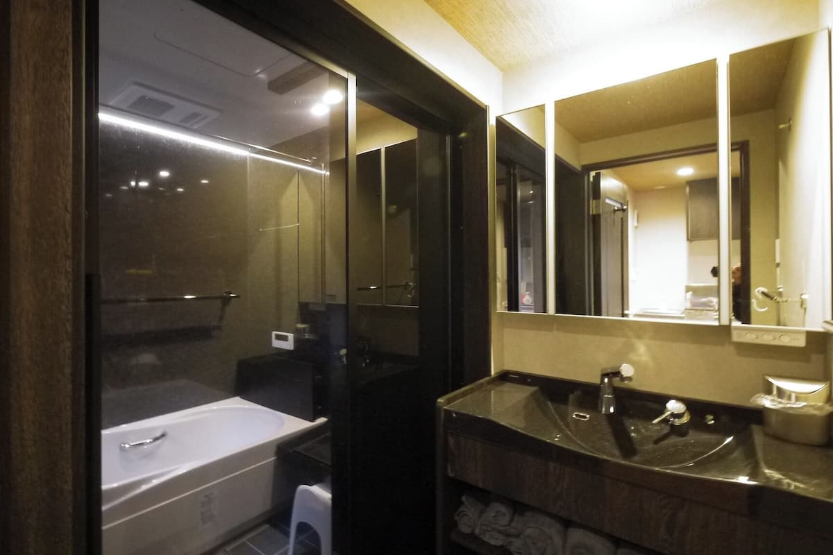 Une salle de bain moderne avec une baignoire, un lavabo et un grand miroir.