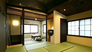 A traditional Japanese room with tatami flooring, a low table, and chairs. - Machiya Kaemon Kyoto sta (Kyoto)