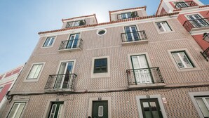 Un edificio de varios pisos con fachada decorada, balcones y ventanas.