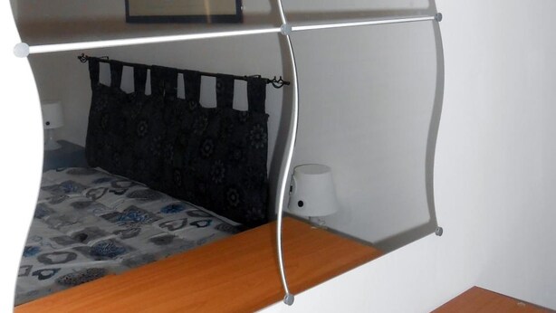 A room with a bed, a bedside table, a lamp, and a framed picture on the wall. - Mary''s Sweet Home Appartamento Napoli (Naples)