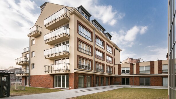 A multi-story residential building with balconies, brickwork, and a courtyard. - City Of The Kings Arianska Garden (Kraków)