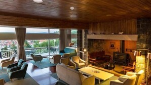 Un salon spacieux doté d’une cheminée, de sièges confortables et d’un balcon offrant une vue agréable.