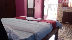 Habitació amb llit, armari, porta i un paviment amb disseny.