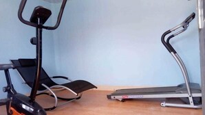 Una habitació amb una bicicleta estaciónia i una cinta de córrer.