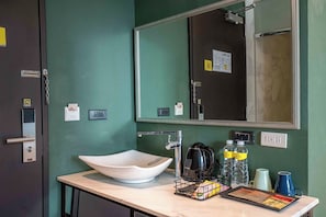 Ein Badezimmer mit Waschbecken, Spiegel, Handtuchhalter und Toilettenartikeln.