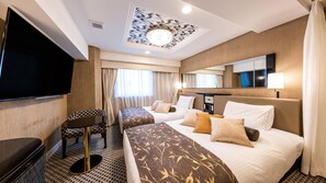 Une chambre d’hôtel avec deux lits, une télévision, un bureau et un miroir.