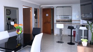 Eine moderne Küche mit weißen Schränken, einer schwarzen Arbeitsplatte und einem eingebauten Backofen.