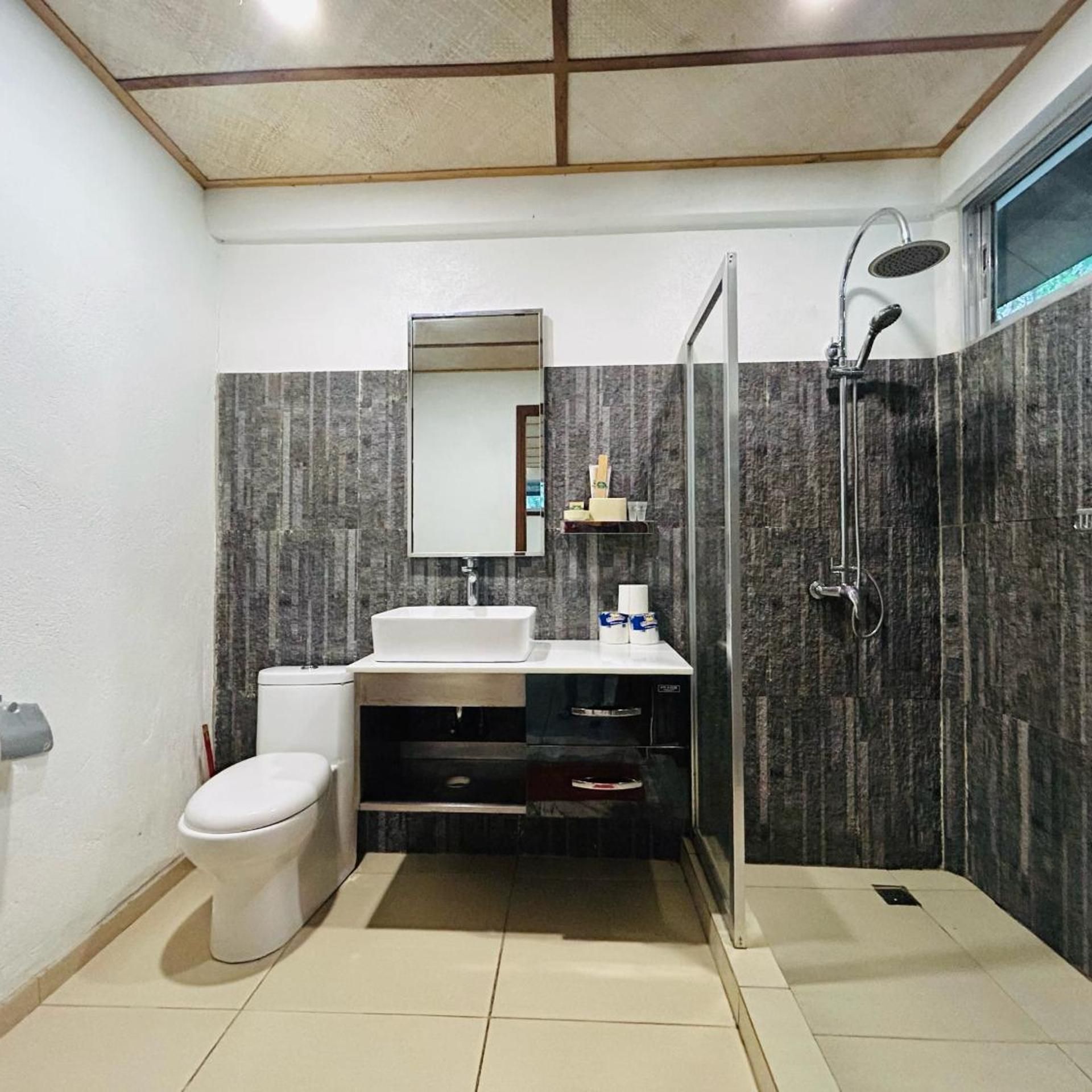 Een moderne badkamer met toilet, wastafel en douche.