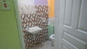 Une salle de bain avec un mur recouvert de carreaux à motifs, un lavabo et des toilettes.