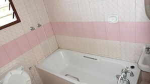 Een badkamer met een bad, toilet en wastafel.