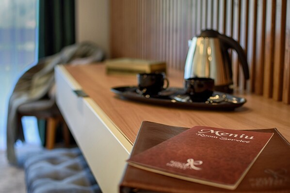 A hotel room with a wooden desk, a tray with a coffee pot and cups, and a menu on the table. - Hotel Rina Sinaia (Sinaia)