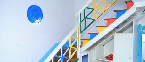 A staircase with colorful railings and a wall-mounted globe.