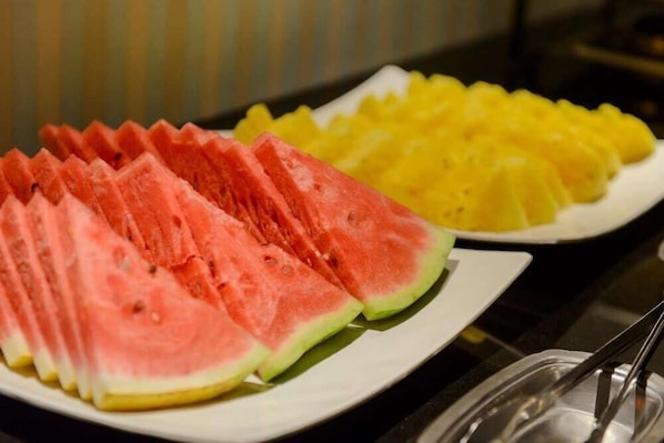 Une assiette de tranches de pastèque et de morceaux d’ananas.