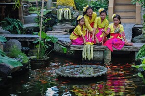 A pond with fish and plants, surrounded by rocks and greenery. - Uma Shanty by Madhava (Karangasem)