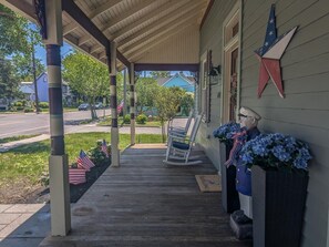 A porch with a rocking chair, American flags, and a star decoration. - NEW 4BR WCM - Linens Included, Beach Box, Pet Friendly (West Cape May)