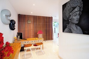 Een moderne eethoek met een houten tafel, stoelen en een decoratieve lamp.