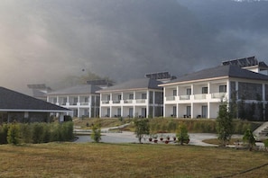Un hôtel moderne à plusieurs étages, chaque étage étant doté de balcons et de panneaux solaires.