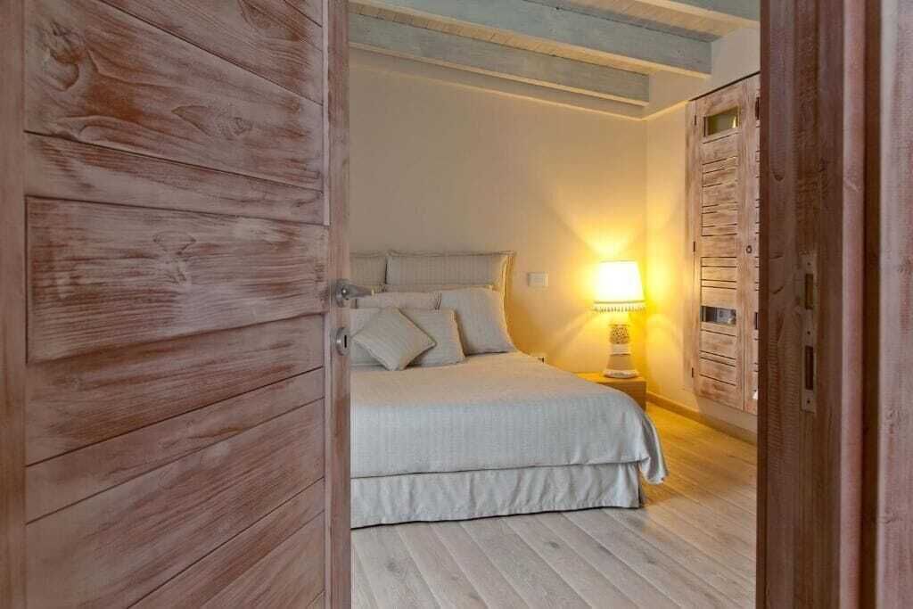 A bedroom with a bed, a nightstand, and a lamp.