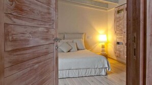 Une chambre à coucher avec un lit, une table de chevet et une lampe.