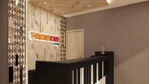 A reception desk with a modern design, a sign reading "FRONTONE CASINO", and patterned walls. - Front One Cabin Malioboro Jogja (Yogyakarta)