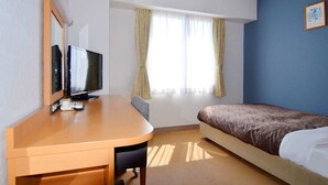 A hotel room with a wooden desk, a television, a bed with a patterned bedspread, a window with curtains, and a blue accent wall. - Hotel Raffinato Sapporo (Sapporo)