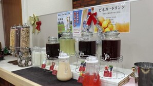 A beverage station with various drinks in glass containers, some with labels and price tags. - Hotel Raffinato Sapporo (Sapporo)