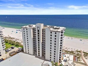 A high-rise hotel with multiple floors, located near a beach with clear blue waters. - Broadmoor 705 | Beachfront | Pool & Hot Tub | My Beach Getaways (Orange Beach)