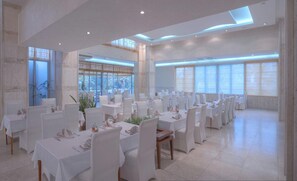 A spacious dining area with multiple tables, chairs, and large windows allowing natural light. - Mediteran Wellness & Spa, Congress Center (Bečići)