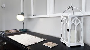Un escritorio con un calendario, una lámpara y un farol blanco.